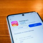 A smartphone displaying the Instagram app open option on a wooden table.